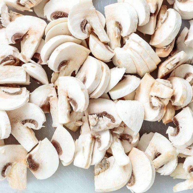 Fresh sliced white mushroom in brine in plastic drums