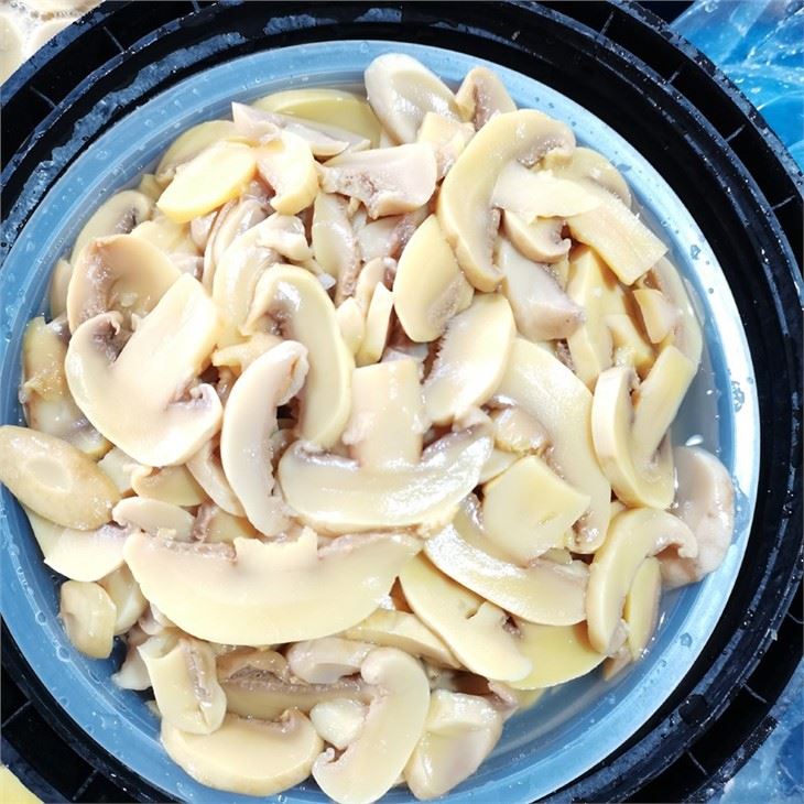 Food sliced white champignon mushroom in brine in drums